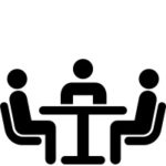 3 personnes assises alentour d'une table en ombrage
