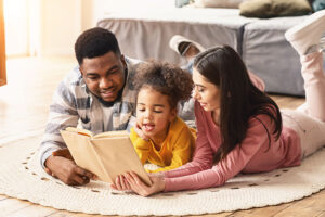Un couple en coparentalité qui lit une histoire à une petite fille